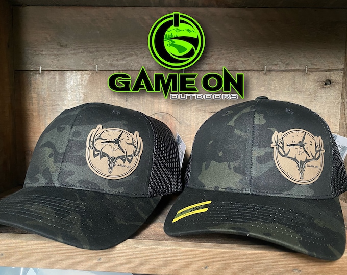 GAMEONGAMEOVER buck and bull SnapBack hat with a broad head puncture patch.