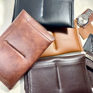 K&ouml;nnte beinhalten: Vier Uhrenboxen aus Leder in verschiedenen Farben: Braun, Schwarz, Dunkelbraun und Beige. Die Boxen haben zwei F&auml;cher zum Aufbewahren von Uhren.