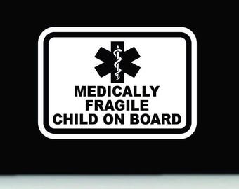 May include: A rectangular sticker with a white background and a thick black border. It features a black Star of Life symbol at the top. Below the symbol, the text reads MEDICALLY FRAGILE CHILD ON BOARD in bold, black, sans-serif capital letters.