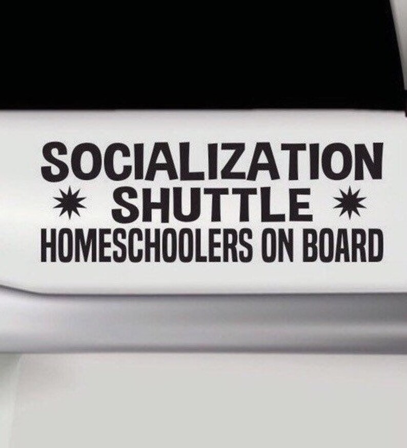 May include: A black vinyl decal applied to a white surface featuring the text SOCIALIZATION SHUTTLE with two star symbols on either side of the word SHUTTLE and the text HOMESCHOOLERS ON BOARD printed in a bold sans-serif font below.