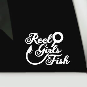 May include: A white vinyl decal sticker featuring the stylised text Reel Girls Fish, with the letter l in Reel designed as a fishing rod and the letter s in Girls shaped like a fishing hook, displayed against a solid black background.