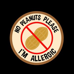 Può includere: Un adesivo circolare beige e marrone con la scritta "NO PEANUTS PLEASE I'M ALLERGIC" in nero e un simbolo di arachide rosso con una linea rossa che lo attraversa. Lo sfondo è nero.