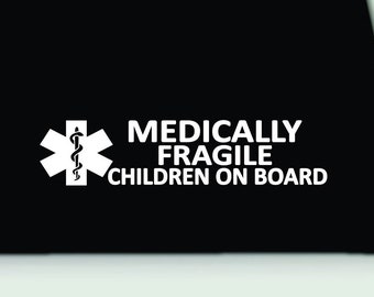 May include: A black decal featuring a white Star of Life symbol with a serpent and staff, accompanied by the white text "MEDICALLY FRAGILE CHILDREN ON BOARD" in a bold, sans-serif font, designed for high-contrast visibility on a smooth surface.