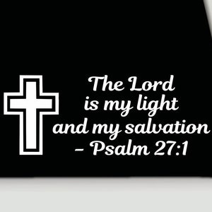 Può includere: Grafica di una croce bianca con il testo "The Lord is my light and my salvation - Psalm 27:1" su sfondo nero. La croce è delineata in nero.