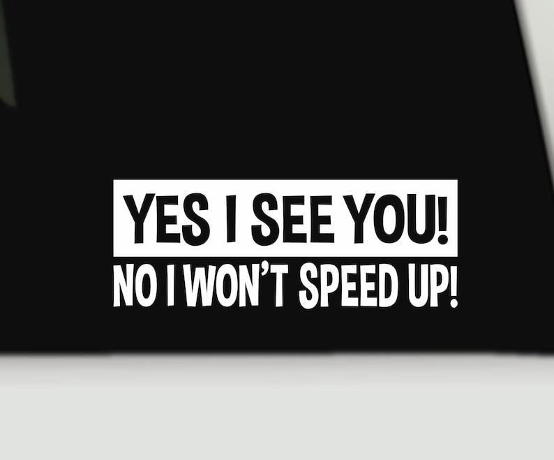 May include: A white vinyl decal sticker featuring the bold black text YES I SEE YOU! inside a rectangular box, followed by the text NO I WON'T SPEED UP! in a matching sans-serif font, designed for application on a smooth surface.