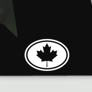 May include: White oval sticker with a black maple leaf emblem, representing Canada. The maple leaf is centrally positioned within the oval, which has a white border. The sticker is set against a black backdrop.