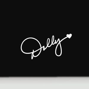 May include: A white graphic decal on a solid black background featuring the word Dolly written in a continuous cursive script font. The letter D is stylized with a large loop, and the end of the word features a small solid white heart icon.