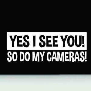 Può includere: Un cartello bianco con testo nero che dice "YES I SEE YOU! SO DO MY CAMERAS!"