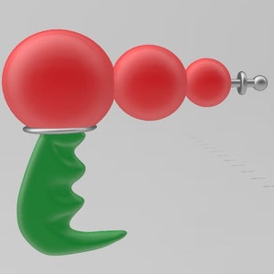 Puede incluir: Una pistola de rayos de juguete roja y verde con una punta plateada. La pistola tiene un mango verde y tres esferas rojas.