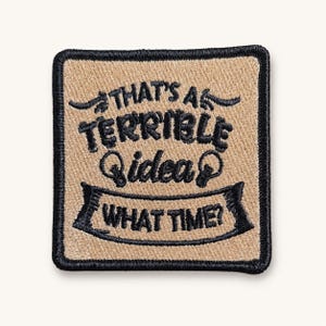May include: A square embroidered patch with a tan background and a black border. The text reads "THAT'S A TERRIBLE idea WHAT TIME?" in black thread, featuring two small lightbulb icons flanking the word idea and a banner graphic below.
