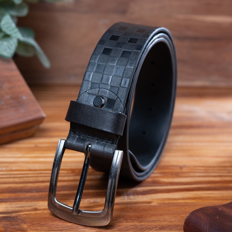 May include: A black leather belt with a checkered pattern and a silver buckle.