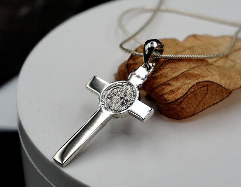 May include: Silver St. Christopher pendant necklace with a cross design and a round medal featuring a religious image.
