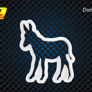 Könnte beinhalten: Weißer Plastik-Ausstecher in Form eines Esels. Der Ausstecher befindet sich auf einem schwarzen und blauen Hintergrund.