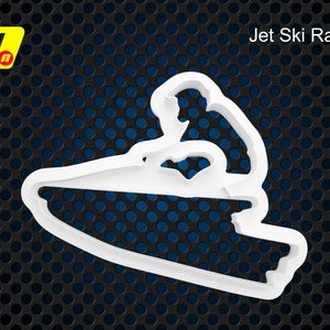 May include: White plastic cookie cutter shaped like a person riding a jet ski. The text "Jet Ski Racer" is above the cutter.