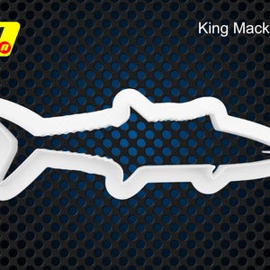 Könnte beinhalten: Weißer Plastik-Ausstecher in Form eines Königsmakrelenfisches. Der Ausstecher befindet sich auf einem schwarzen Hintergrund mit einem sich wiederholenden Muster aus kleinen Kreisen.