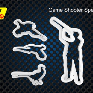 Könnte beinhalten: Weiße Plastik-Ausstecher in Form eines Jägers mit einer Waffe, einem Vogel und zwei kleineren Vögeln. Der Text "Game Shooter Special" befindet sich oben im Bild.