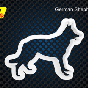 May include: White plastic cookie cutter shaped like a German Shepherd dog. The cookie cutter is on a black and blue background.