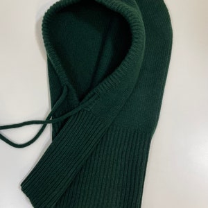 May include: A dark green knitted balaclava with a drawstring.