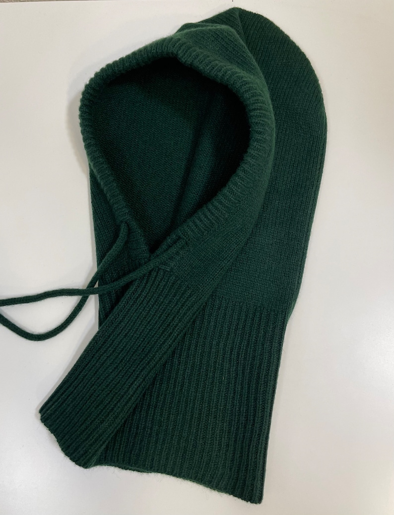 May include: A dark green knitted balaclava with a drawstring.