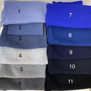 Puede incluir: Un conjunto de once muestras de tela en varios tonos de azul, gris y negro. Las muestras est&aacute;n numeradas del 1 al 11.