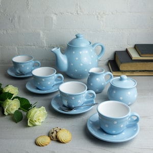 Op de afbeelding: Een blauwe en witte stippen theeservies met een theepot, roomkan, suikerpot en vier kopjes en schoteltjes.