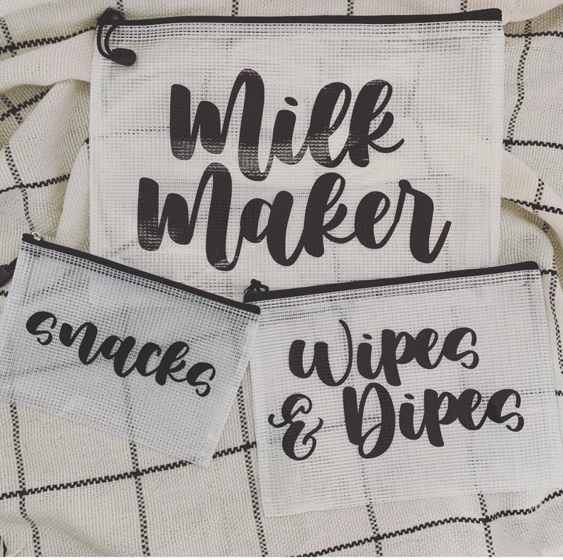 May include: Three white mesh zippered pouches with black text. The largest pouch says "Milk Maker", the medium pouch says "Snacks", and the smallest pouch says "Wipes & Dipees".