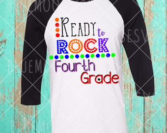 May include: A white and black baseball tee shirt with the text "Ready to Rock Fourth Grade" in rainbow colors with a black star.