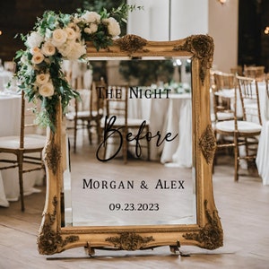 Puede incluir: Un espejo con marco dorado con el texto "The Night Before" en letras cursivas negras, seguido de "Morgan & Alex" y la fecha "09.23.2023".