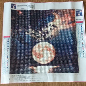 May include: Diamond painting kit featuring a full moon with orange and red hues against a dark blue starry sky. The kit includes a 30x30cm canvas and numbered diamond drills.