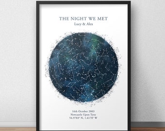May include: A black framed print with a white background featuring a blue and white star constellation map. The text "THE NIGHT WE MET" is at the top of the print, followed by "Lucy & Alex". Below the map is the text "16th October 2003", "Newcastle Upon Tyne", and "54.9783° N, 1.6178° W".