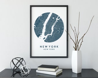 May include: A framed print of a blue and white map of New York City with the text "NEW YORK" and "NEW YORK" below the map.
