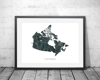 Könnte beinhalten: Ein schwarz-weiß gerahmter Druck einer Aquarellkarte von Kanada. Die Karte ist in Grün- und Blautönen gehalten, mit dem Wort "CANADA" darunter.