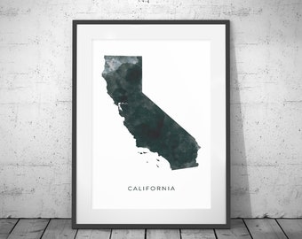 May include: A framed print of a watercolor illustration of the state of California. The map is in shades of dark green and gray. The word "CALIFORNIA" is printed in black at the bottom of the print.