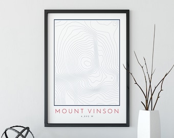 May include: A black framed print with a topographic map of Mount Vinson, the highest peak in Antarctica. The print has the text "Mount Vinson" and "4,892 M" in red and blue.