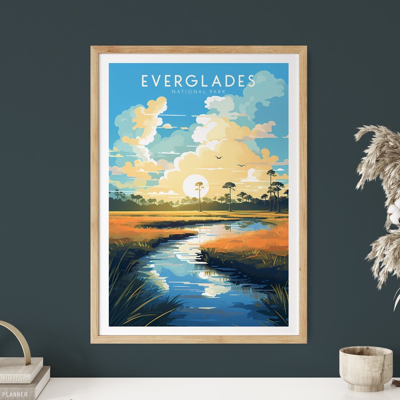 May include: A vintage-style poster with a blue sky, white clouds, and a sun setting over a river in a grassy field. The text "EVERGLADES NATIONAL PARK" is at the top of the poster.