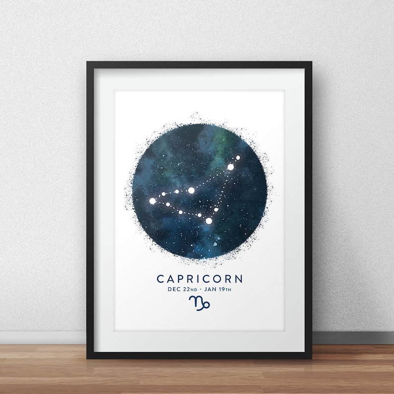 May include: A black framed print with a white background featuring a blue watercolour circle with white stars forming the constellation Capricorn. The text "CAPRICORN DEC 22ND - JAN 19TH" and the Capricorn zodiac symbol are below the circle.
