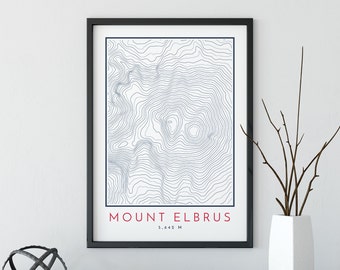 May include: A black framed print with a topographic map of Mount Elbrus, a mountain in Russia. The print has the text "Mount Elbrus" and "5,642 M" in red.