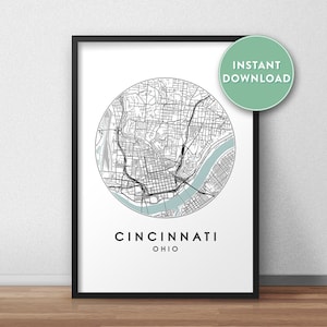 Puede incluir: Mapa imprimible de Cincinnati, Ohio, con líneas negras que muestran las calles de la ciudad y un río azul. El mapa está en un círculo con las palabras "Cincinnati, Ohio" debajo.