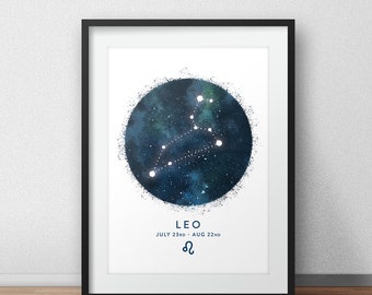 May include: Framed art print featuring the Leo constellation. The artwork displays a dark blue and green watercolor-style circle with the constellation's stars connected by white lines. The word "LEO" and the dates "JULY 23RD - AUG 22ND" are printed below the circle.