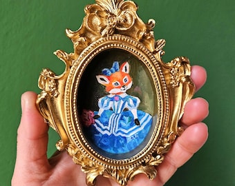 Miniatura de la Princesa Zorra: Vestido renacentista, lazo azul y marco barroco