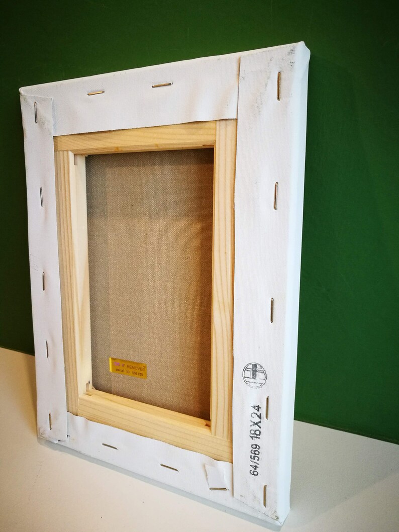 Puede incluir: La parte posterior de un marco de lienzo de madera con lienzo blanco estirado alrededor. El marco est&aacute; asegurado con grapas. Una etiqueta amarilla con el texto "Art Removed" es visible en el marco. El marco tiene un sello negro con el texto "64/569 18X24".