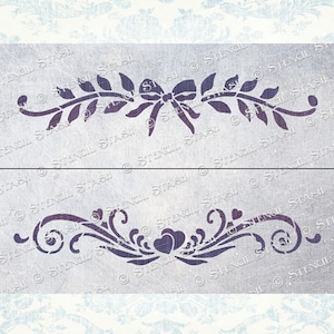 May include: Two decorative stencils, one with a leafy vine and a bow in the center, and the other with a swirling vine and two hearts in the center.