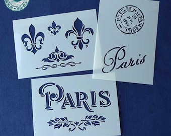 Op de afbeelding: Verschillende witte sjablonen met donkerblauwe ontwerpen worden getoond tegen een blauwe achtergrond. De sjablonen bevatten fleur-de-lis-motieven, decoratieve randen en het woord "Paris" in elegant schrift en hoofdletters. De tekst "Image Copyright Stencil Stash" is ook opgenomen.