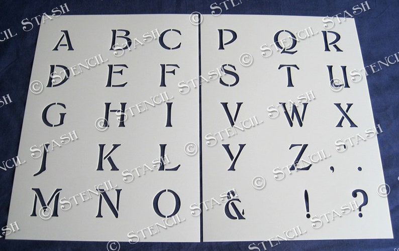 May include: A white stencil sheet with the alphabet in uppercase letters, numbers, punctuation marks, and an ampersand. The letters are in a traditional serif font.
