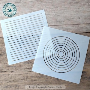 May include: Two white plastic stencils, one with a grid pattern and the other with a concentric circle pattern.  The stencils are on a wooden surface.  Image Copyright Stencil Stash.