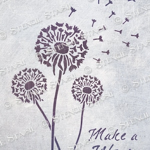 Könnte beinhalten: Ein Schablonen-Design mit drei Löwenzahnpflanzen, deren Samen im Wind fliegen. Der Text "Make a Wish" steht unter den Löwenzahnpflanzen.