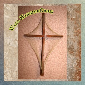 May include: A wooden wall hanging cross with a string design. The cross is brown and the strings are a light beige color. The text "WALL HANGING CROSS" is written in yellow letters on the top left corner of the image.