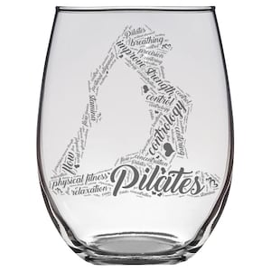 May include: A clear glass wine glass with a gray word cloud design featuring the word "Pilates" and related terms like "breathing", "control", "strength", and "concentration".