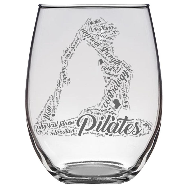 May include: A clear glass wine glass with a gray word cloud design featuring the word "Pilates" and related terms like "breathing", "control", "strength", and "concentration".