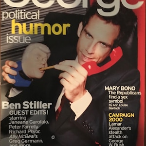 May include: The "George" magazine cover shows Ben Stiller with a red telephone. The magazine's title is in white, with "political humor issue" in yellow. A caricature of a person is also visible.